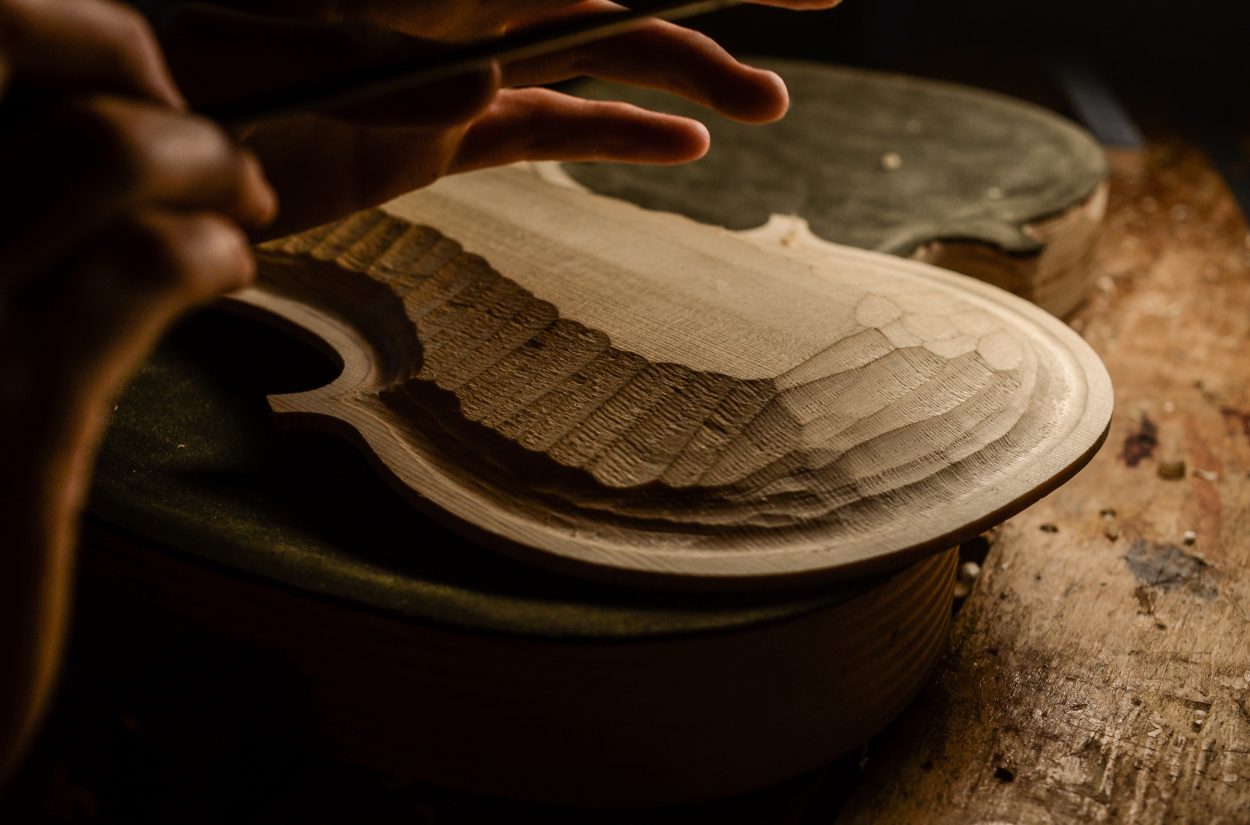 hands of artisan woman violin maker luthier working in the back table of a new hand made cremonese violin